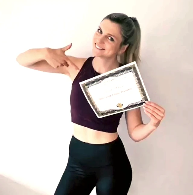 Absolventin der Training Academy zeigt stolz ihr Diplom